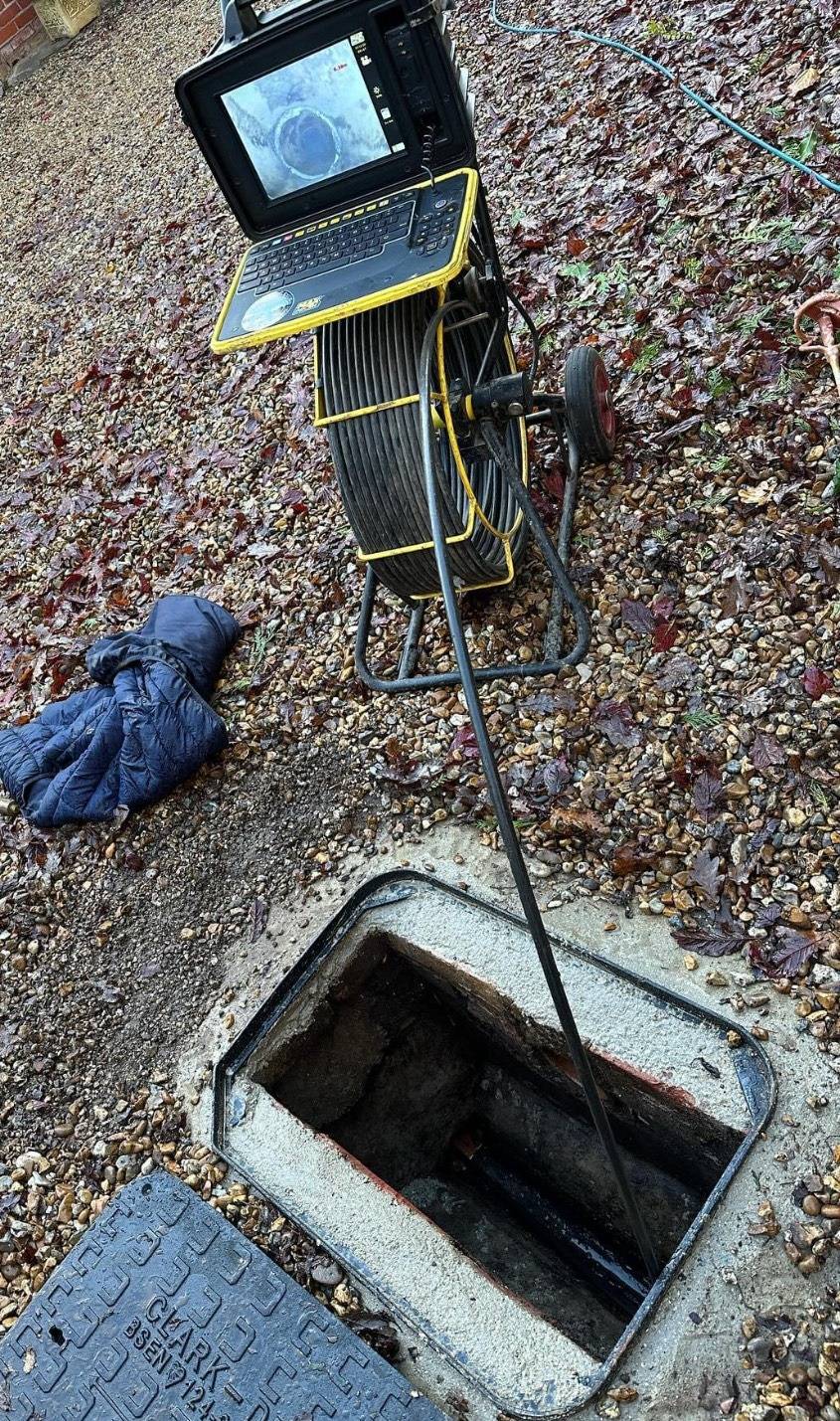 CCTV drain survey equipment set up at a manhole for pipe inspection