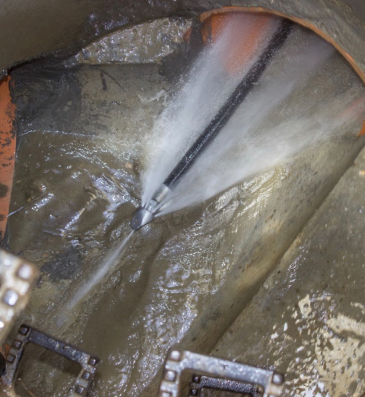 High-pressure water jetting inside a drain pipe clearing blockages